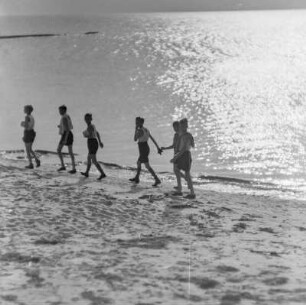 Jugendliche laufen am Strand entlang