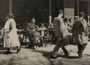 Spanien. Barcelona. Vor einem Straßencafe am frühen Vormittag. Zwischen den Tischen und Gästen gehen die zahllosen Schuhputzer ihren Geschäften nach