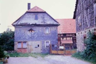 Giebel eines Bauernhaus und Hofzufahrt, sanierungsbedürftig