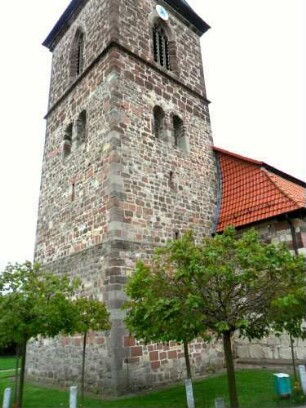 Evangelische Kirche - Kirchturm von Südwesten mit Schießscharten (Schlitzscharten) sowie veränderten Biforien und gotischem Glockengeschoß in Übersicht
