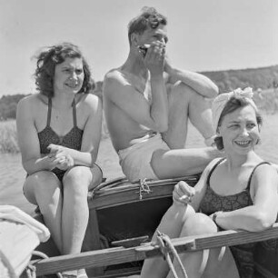 Elisabeth Gremmler (rechts) und ein befreundetes Paar sitzen auf einem Segelboot, der Mann spielt Mundharmonika