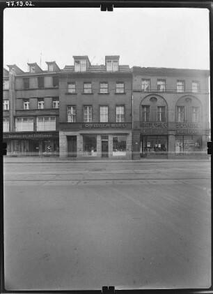 Cottbus-Mitte, Berliner Straße 158/154. Wohnhäuser mit Läden (Tabakwaren und Spirituosen / Fleisch - Wurst / Kreuz-Drogerie). Straßenfront