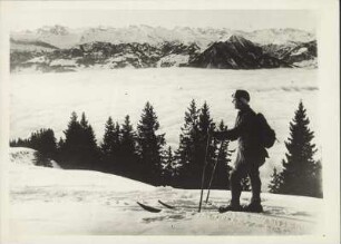 Die Schweiz im Winter. Ein Skifahrer auf dem Rigi. Man blickt vom Bergmassiv in Richtung Berner Oberland. Über dem Vierwaldstättersee liegt eine Nebelwand