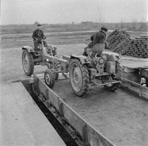 Schönebeck. VEB Traktorenwerk Schönebeck. Produktionsbereich Geräteträger RS 09. Werkfahrer bei Auffahrt zweier Geräteträger auf einen Eisenbahn-Flachwagen