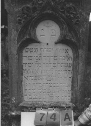 Grabstein 74 (Index: 99799555) Material: Sandstein, Schriftplatte Marmor Zustand: verwittert Maße HxBxT: 197x61x26 cm Beschreibung: Stele, Mittelerhöhung, Verdachung, Mittelpalmette, eingelassene Schriftplatte mit Kleeblattbogenabschluß, getreppter Sockel Symbolik: floral: Grabstein 74A
