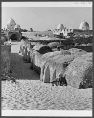 Dorf der Souf-Region : Ein Dorf der Souf-Region in der Nähe der algerischen Stadt El Oued. Die Gebäude weisen die für die Souf-Region charakteristischen Kuppeldächer auf. Im Hintergrund sind neben der Oase Wanderdünen erkennbar