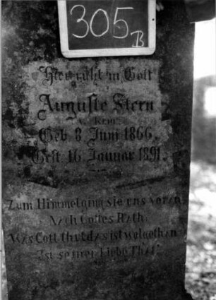 Grabstein 305 (Index: 100112006) Material: Sandstein Zustand: leicht verwittert Maße HxBxT: 151x60x27 cm Beschreibung: Stele, getreppter Sockel, giebelartiger Abschluß mit Verdachung, rechteckiges Schriftfeld eingetieft mit rund eingezogenen Ecken Symbolik: Kranz mit Schleife: Grabstein 305B