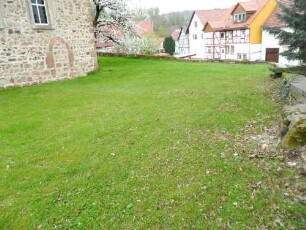 Heina-Evangelische Kirche - Kirchhof im Süden nach Osten mit Kirchhofmauer in übersichtlichem Verlauf