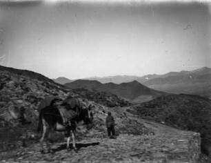 Bergpfad : Ein Mann unterwegs mit einem Pferd auf einem steinigen Pfad unterwegs