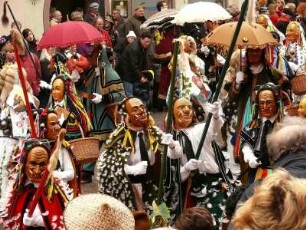 Rottweiler Narrensprung : Der größte und traditionsreichste Narrenumzug Baden - Württembergs wird in Rottweil dreimal im Jahr veranstaltet, am Fasnetsmontag und am Fasnetsdienstag. Tausende Narren ziehen durch die Stadt, auch Kleinkinder werden schon mit Masken verkleidet. Bild: Narren vor einer steinernen Madnonna. Aufgenommen am Fasnetsdienstag 2008. Foto Uwe Gerig.