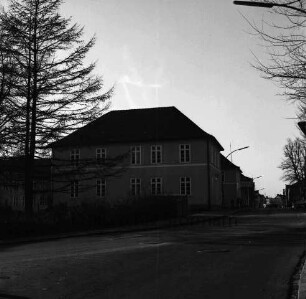 Königstraße: links Baum und Hecke: dahinter Erweiterungsbau der Stadtschule: hinten rechts Personen, Pkws und Wohnhäuser