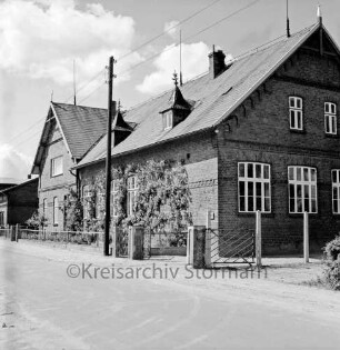 Lasbek-Dorf: Volksschule: Schulstraße: links Strommast: vorn Vorgarten und Tor zum Schulhof