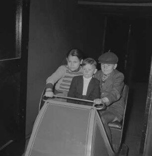 Drei Jungen in einem Wagen beim Besuch einer Geisterbahn