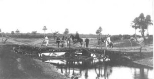 Gruppenbild mit Ernst Otto Gerhardt und Einheimischen auf einer hölzernen Brücke, aufgenommen in Argentinien