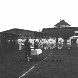Sport- und Schützenverein (SSV) Pölitz e.V.: 40-jähriges Jubiläum: Vorsitzendern Kurt Riemann an Tisch mit zwei Jungen: dahinter Oldesloer Spielmannszug "Union": im Hintergrund Schießhalle