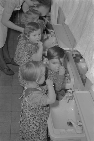 Kinderkrippe. Erzieherin mit Kindern im Waschraum beim Zähneputzen : Deutsche Demokratische Republik. Kinderkrippe. Erzieherin mit Kindern im Waschraum beim Zähneputzen