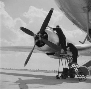 Leipzig-Mockau. Flughafen, Vorfeld. Zwei Techniker bei Wartungsarbeiten an einem Flugzeugmotor