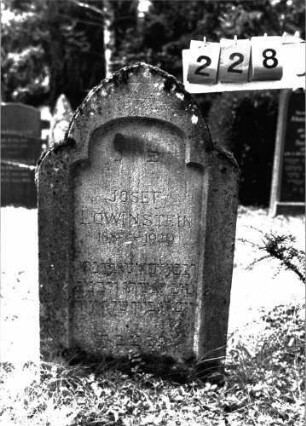 Grabstein 228 (Index: 100101949) Material: Sandstein Zustand: leicht verwittert Maße HxBxT: 92x54x14 cm Beschreibung: Stele, rund eingezogener Spitzbogenabschluß, Schriftfeld eingetieft mit rund eingezogenem Korbbogenabschluß Symbolik: Davidstern: Grabstein 228