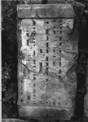 Grabstein 236 (Index: 100110524) Zustand: zwei zusammengehörige Fragmente, sehr stark verwittert mit großem Textverlust, ehemals schwarze Schrift Maße HxBxT: 45x82x11 cm Beschreibung: Schriftfeld eingetieft (Fragmente) Besonderheit: Maße des zweiten Fragmentes: 41/83/11: Grabstein 236 (Detailaufnahme 2)