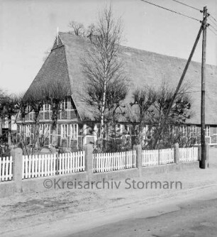 Oetjendorfer Landstraße: Bauerngehöft des Bürgermeisters Erwin Schulz mit Fachwerk: davor Baumreihe: vorn Holzzaun: rechts Strommast