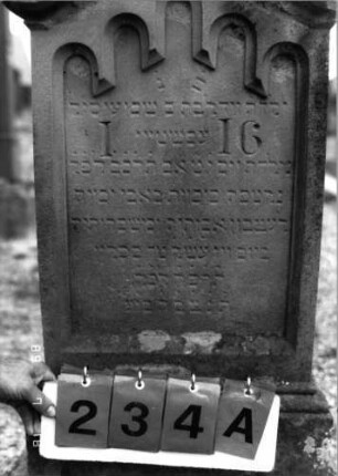 Grabstein 234 (Index: 99797715) Material: Sandstein, weiß Zustand: stark verwittert Maße HxBxT: 107x60x20 cm Beschreibung: Stele, Giebel rechteckig erhöht, profilierter Sockel Symbolik: Rundbogenfries: Grabstein 234A