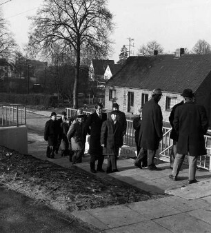 Kreisstraße zwischen Klein Wesenberg und Lübeck: Einweihung und Freigabe: Besichtigung der neuen Sackgasse Im Grund mit Stützmauer und Fußgängertreppe durch Funktionsträger und Gäste: hinten Bäume und Häuser