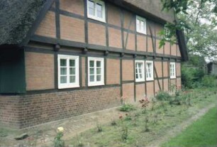 Hohenfelde 1: traufständiges Fachhallenhaus mit Reetdach: Giebelseite Wohntrakt: Fachwerk mit Ausmauerung, Vorkragung, Sprossenfenster