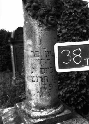 Grabstein 38 (Index: 100100871) Material: Sandstein Zustand: Säule leicht beschädigt Maße HxBxT: 185x54x54 cm Beschreibung: Säulenstumpf, getreppter Sockel, unterster Sockelteil rusticaartig Symbolik: Blumenkranz um Säulenstumpf: Grabstein 38B
