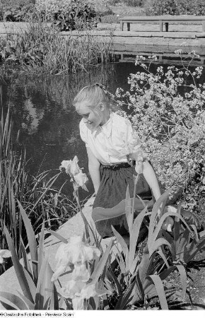 Mädchen, an einem Ufer sitzend