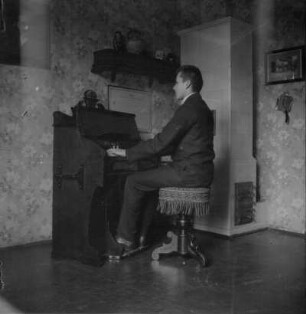Um Gurlitts. Fernerstehende. Mann, auf einem Harmonium spielend (Hensel?)