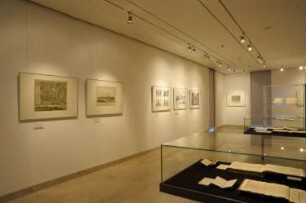Exponate an der Süd-Wand (Karten, Theaterbauten) und Ausstellungsvitrinen mit Musikalien