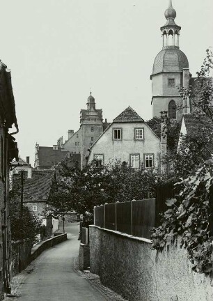 Colditz, Blick durch eine Gasse zum Schloss mit Turm der Stadtkirche St. Aegidien