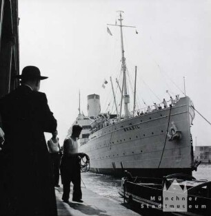 Genua. Ein großer Überseedampfer wird in den Hafen gelotst