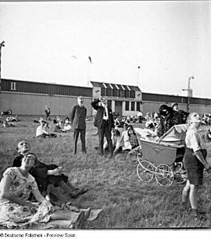Berlin-Tempelhof. Flughafen. Deutsche Luftfestspiele 1930. Schaulustige am Rande des Flugfeldes. Im Hintergrund die 1925 fertiggestellten Flugzeughallen