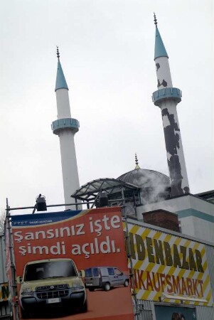 Minarette der Ar Raudhah - Moschee. Im Vordergrund türkisch-sprachige Auto-Werbung. Hamburg, St. Georg, 03.2005