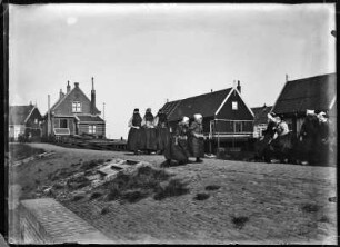 Niederlande, Marken. Deich mit Passanten und Wohnhäusern