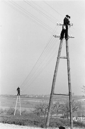 Oberleitung : Energieversorgung. Arbeiten an einer Oberleitung. Ansicht mit zwei Arbeitern auf Masten