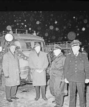 Freiwillige Feuerwehr Bargfeld: 75-jähriges Jubiläum: Übergabe des neuen Löschfahrzeugs: mit Girlande geschmücktes Fahrzeug, davor stellvertretender Bürgermeister Hans-Joachim Dassau und Amtswehrführer Gustav Krützfeld: Nacht: Winter