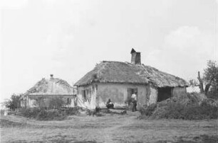 Zweiter Weltkrieg. Zur Einquartierung. Sowjetunion. Zwei Angehörige der deutschen Wehrmacht vor einer Bauernhütte