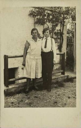 [Mann und Frau vor Hauswand]