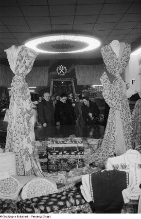 Besucher vor einem Messestand mit Stoffen in der Messehalle des Ausstellungslandes Bulgarien