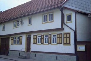 Bauernhaus mit teilweise vorkragendem Obergeschoss, Fenster mit Läden, überbaute Torfahrt