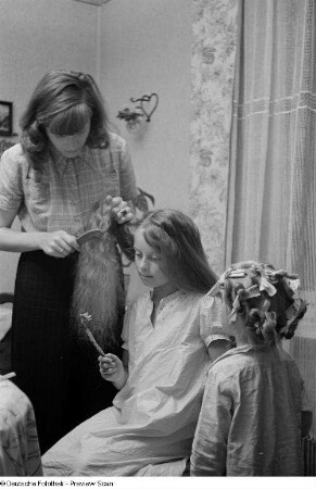 Renate Rössing kämmt einem Mädchen das Haar