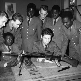 Gruppenaufnahme afrikanischer und deutscher Polizeischüler bei der Ausbildung an einem Gewehr