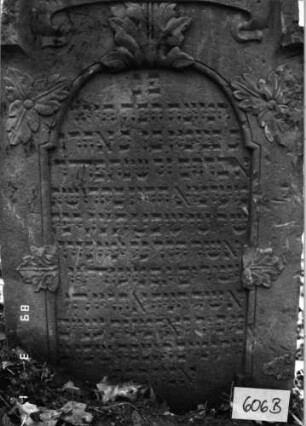 Grabstein 606 (Index: 99753119) Material: Sandstein Zustand: leicht verwittert Maße HxBxT: 113x65x11 cm Beschreibung: eingezog. Kielbogenabschl. , Schriftfeld eingetieft m. eingezog. Rundbogenabschluß Symbolik: Blätter, Schriftband: Grabstein 606B