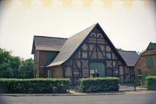 Hauptstraße 38: Bauernhaus: straßenseitiger Giebel Wirtschaftstrakt mit Scheunentor nach Renovierung, Ausmauerung der Gefache mit unterschiedlichen Mustern: links und rechts Querbauten: vorne rechts Stallgebäude