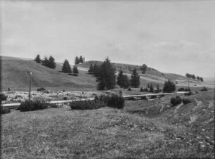 Landschaft : Eine hügelige Landschaft mit einer Holzkonstruktion