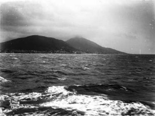 Küste mit Hügeln : Eine Küste mit Hügeln vom Wasser aus fotografiert.