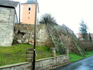 Evangelische Pfarrkirche-Ansicht im Südosten mit Kirchhofmauer und stabilisierenden Strebepfeilern von Ortsseite (Wehrgang mit Steinbrüstung im 19 Jh abgetragen)