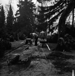 Neuer Friedhof: Hamburger Straße: ältester Teil: Befestigen eines Fußweges mit Betonplatten: zwei Arbeiter mit Schaufel und Schubkarre